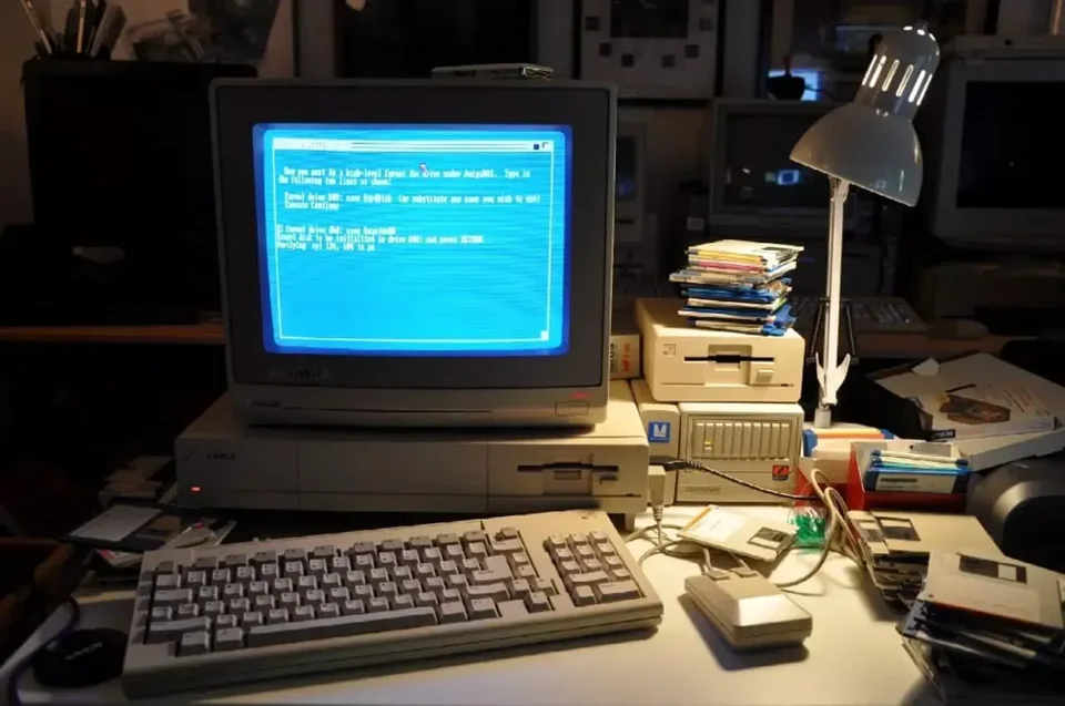 Vintage computer with a blue screen and floppy disks